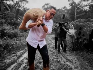 BALADA SEORANG MENTERI MEMANGGUL BERAS KE LOKASI BENCANA SAMBIL BERLARI